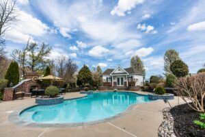 swimming-pool-with-parasol,-tables,-and-chairs