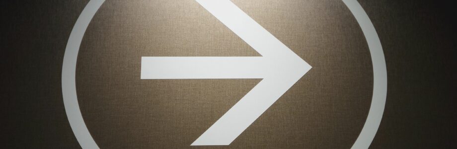 white-arrow-signage-on-black-wall