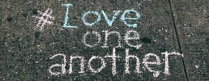 love-one-another-chalk-written-on-concrete