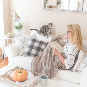 cat-on-couch-with-woman-reading-a-book